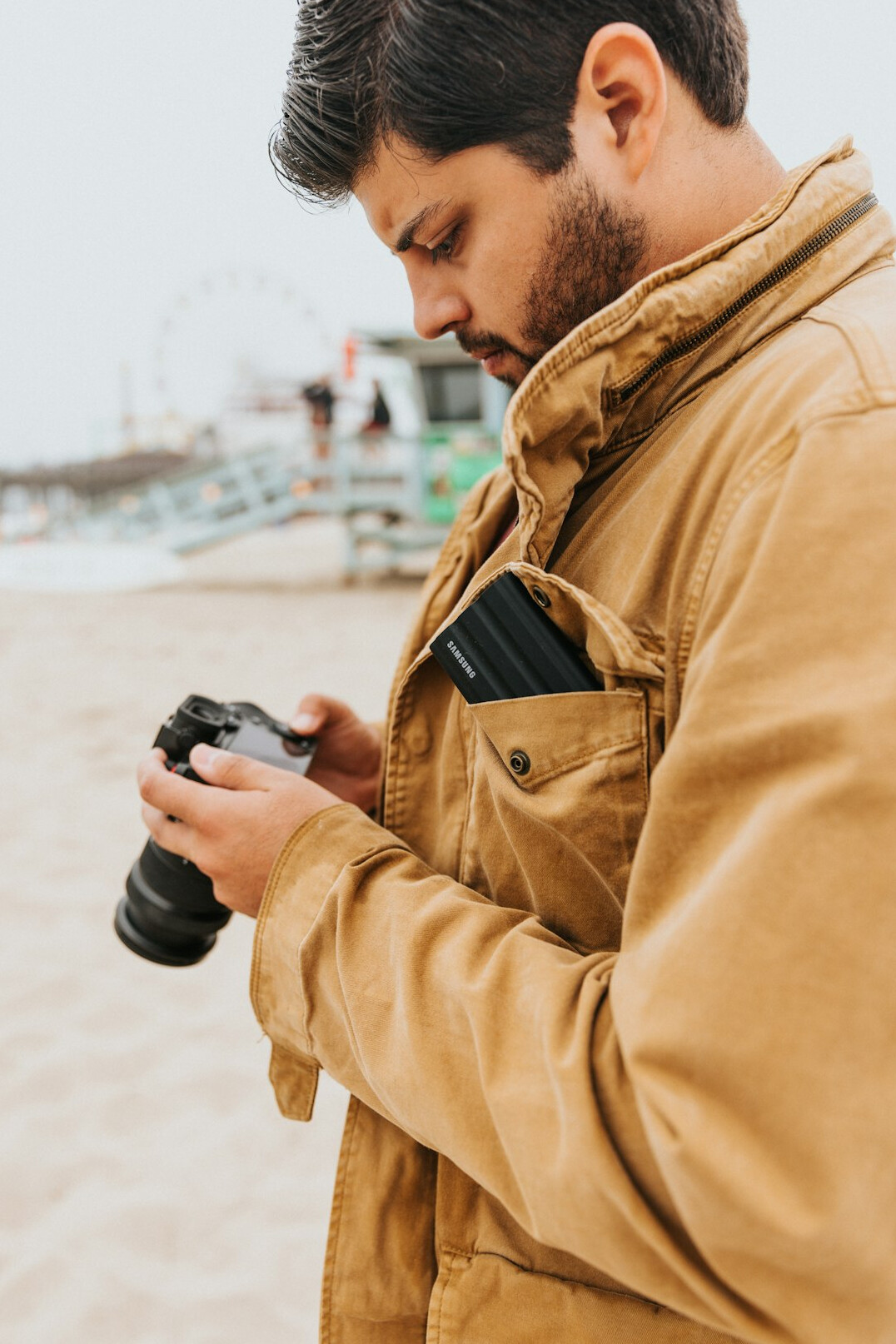 Male photographer holding a camera while working outdoors