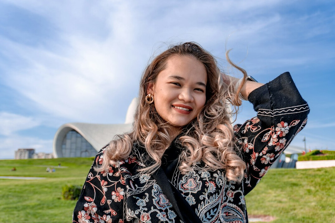 Woman with curly hair smiling outdoors